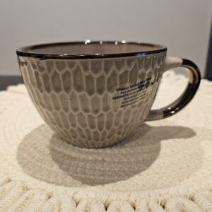 Beige mugg med guldfärgade detaljer